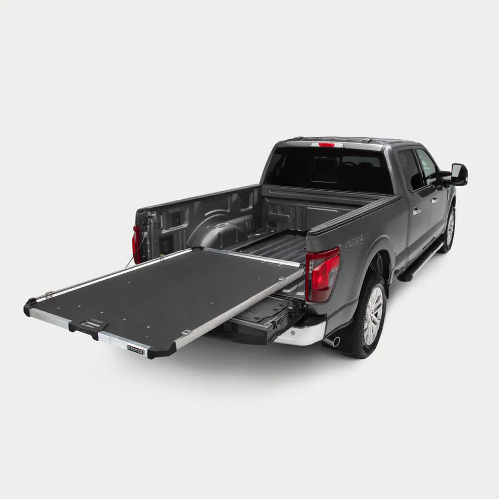 Gray pickup truck with an extended DECKED CargoGlide sliding bed tray on a light neutral background