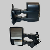 Pair of black power heated telescoping towing mirrors for Ford Super Duty on a light neutral background