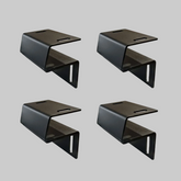 Set of four black Ironhaul modular bed rack adapter brackets on a light neutral background