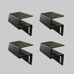 Set of four black Ironhaul modular bed rack adapter brackets on a light neutral background