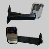 Pair of black and chrome power heated towing mirrors for RAM trucks on a light neutral background
