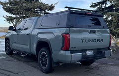 Grey Toyota Tundra with an IRONHAUL aluminum truck canopy V2, side access door, rear window, and roof cross bars