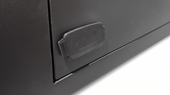 Close-up of a black metal cabinet door with a recessed plastic handle on a white background.