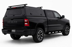 Black RAM pickup truck with an IronHaul aluminum truck canopy, side compartments, and roof racks.