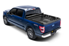 Blue Ford F-150 with the TruXedo TruXport soft roll-up tonneau cover fully open for complete truck bed access