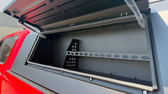 Interior view of an IRONHAUL aluminum truck canopy with the side access door open and interior mounting rails
