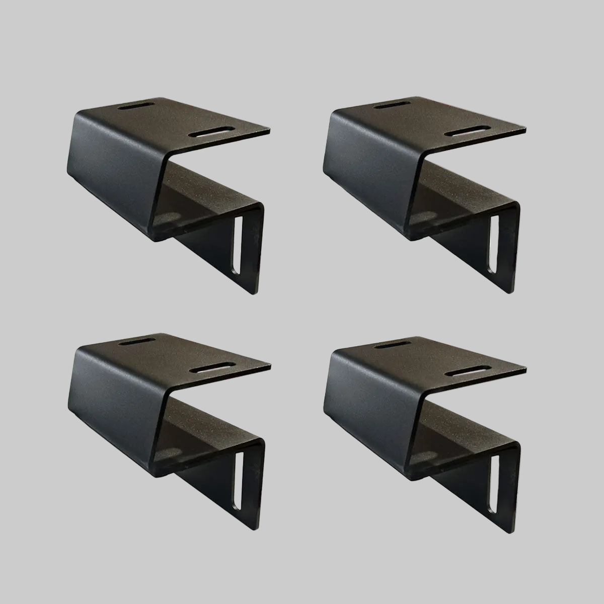 Set of four black Ironhaul modular bed rack adapter brackets on a light neutral background