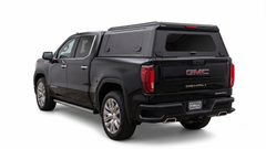 Black GMC Sierra Denali with an IRONHAUL aluminum truck canopy, shown from the rear on a white background.