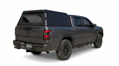 Grey Nissan Frontier PRO-4X with a black IRONHAUL aluminum truck canopy and rear window