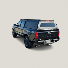 Ironhaul Toyota Tacoma Aluminum Truck Canopy V2, rear three-quarter view on a light neutral studio background